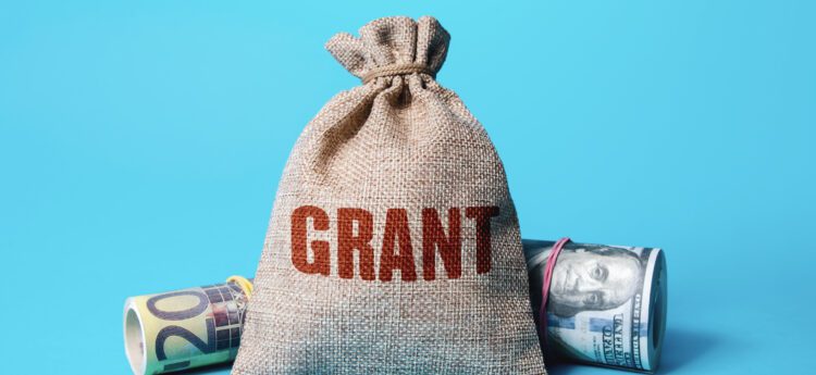 burlap bag with the word Grant on and two rolls of money