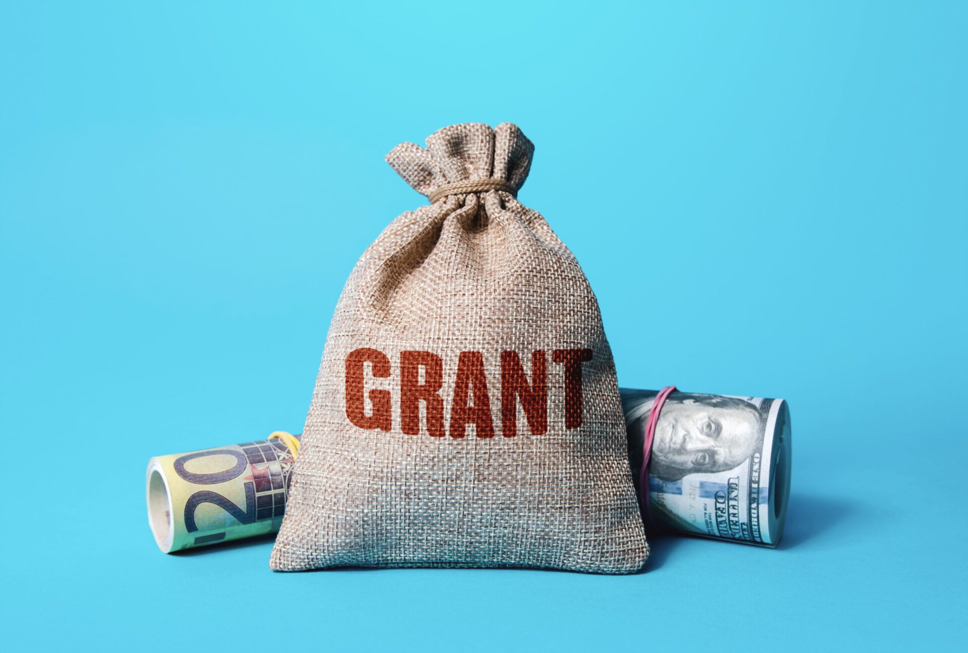 burlap bag with the word Grant on and two rolls of money