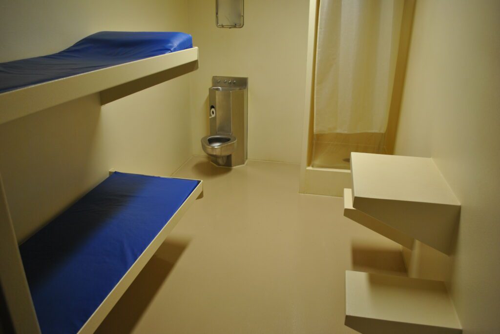 Jail cell with two beds and bathroom