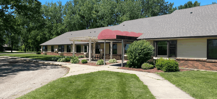 Apartment building entrance with sidewalk and grass
