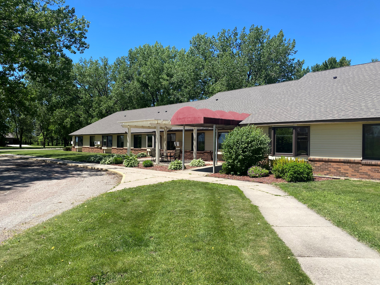 Apartment building entrance with sidewalk and grass